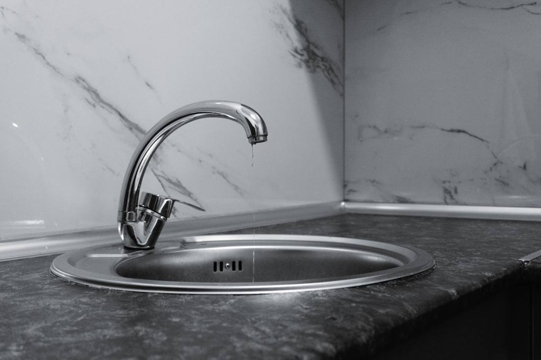 A clean and modern kitchen sink with a chrome faucet, highlighting minimalist design and water conservation.